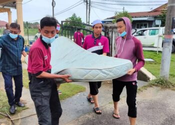 HANAFIAH Mat (kiri) bersama sukarelawan membantu membersihkan rumah penduduk terjejas banjir di Bandar Baru Bukit Mentok, di Kemaman hari ini.-UTUSAN/ NIK NUR IZZATUL HAZWANI NIK ADNAN