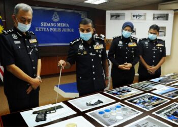 AYOB Khan Mydin Pitchay (dua kiri) menunjukkan gambar pistol separa automatik hasil penemuan senjata api di Sungai Skudai pada sidang akhbar di IPK Johor, Johor Bahru, Johor. - UTUSAN/ RAJA JAAFAR ALI