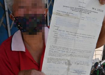 WANITA warga emas menunjukkan menunjukkan notis kompaun yang diterimanya akibat tidak memakai pelitup muka di Pasar Bukit Cina, Melaka.