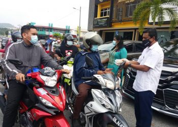 MOHD. Shaid Rosli (kanan) memberi makanan percuma secara pandu lalu kepada orang ramai di hadapan pejabat PKM DUN Jeram, Bandar Puncak Alam, Kuala Selangor, Selangor. -  UTUSAN/ISKANDAR SHAH MOHAMED