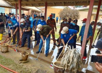 WAN Rosdy Wan Ismail (depan, dua dari kanan) membersihkan longkang pada program gotong royong pasca banjir di SMK Mengkarak di Guai, Bera, Pahang semalam.