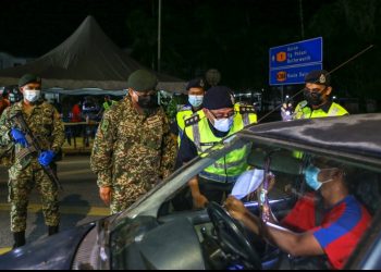 AHMAD Shukri Mat Akhir (tiga dari kiri) memeriksa kenderaan yang melalui sekatan jalan raya berikutan pelaksanaan PKP di hadapan Balai Polis Kota Sarang Semut, Alor Setar malam semalam. - UTUSAN/SHAHIR NOORDIN