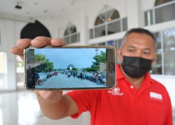 AHLI kariah Masjid At-Taqwa, Paroi, Abd. Aziz Muhamad menunjukkan video yang tular sejak semalam yang mempersoalkan SOP semasa pelaksanaan PKP apabila jemaah  sedang keluar daripada masjid dan selesai menunaikan solat Jumaat.-UTUSAN/ZAKKINA WATI AHMAD TARMIZI.