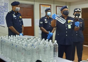 AZHAR Hashim menunjukkan sebahagian daripada arak yang diisi semula ke dalam botol air mineral di Kulim hari ini. - UTUSAN/AZAHAR HASHIM.