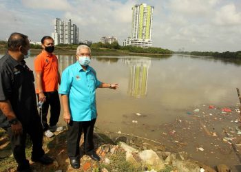 HASSAN Abdul Karim (kanan) menunjukkan sampah sarap dan air yang tercemar di Sungai Tebrau, selepas memberi sumbangan prihatin Covid-19 kepada penduduk Kampung Plentong Tengah,  Pasir Gudang, Johor. - UTUSAN/ BAAZLAN IBRAHIM