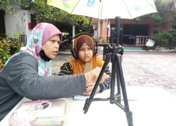 HANIZA (kiri) sedang mempersiapkan Dhiya mengikuti kelas Pendidikan Jasmani di luar rumahnya di Seksyen 30, Shah Alam, Selangor hari ini-UTUSAN/MOHAMAD NAUFAL MOHAMAD IDRIS