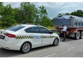 ANGGOTA Polis Trafik mengeluarkan saman terhadap sebuah lori yang melanggar peraturan dan undang-undang lalu lintas di sekitar Iskandar Puteri, Johor.