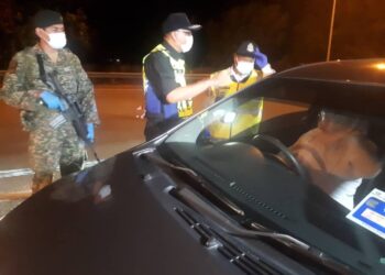 AHMAD Shukri Mat Akhir (tengah) memeriksa kenderaan yang melalui SJR Op Covid-19 di Plaza Tol Alor Setar Selatan, Alor Setar malam semalam. - UTUSAN/ZAID MOHD. NOOR