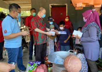 WEE Ka Siong (dua dari kiri) menyampaikan telefon bimbit kepada salah seorang anak Umi Naza Osman bagi memudahkan mereka mengikuti PdPR di Kampung Rahmat, Ayer Hitam, Batu Pahat, Johor.