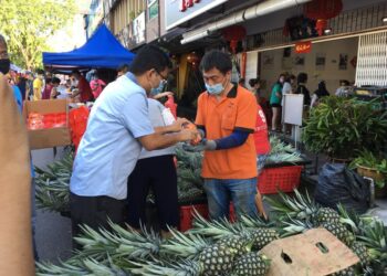 AKMAL Nasrullah Md. Nasir (kiri) memberikan sumbangan limau dan cecair pembasmi kuman sempena Tahun Baharu Cina ketika melawat Pasar Pagi Taman Pelangi di Johor Bahru, Johor.