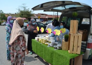 PENDUDUK sekitar tidak melepaskan peluang membeli makanan tradisi Negeri Sembilan yang dijual pihak Hotel Klana Beach Port Dickson di Taman Intan Perdana, Port Dickson hari ini.-UTUSAN/ZAKKINA WATI AHMAD TARMIZI.