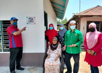 NOH (kiri) bersama Hamidah (berkerusi roda) di hadapan rumah bantuan PUNB itu di Kampung Bagan Tengkorak,Tanjong Karang, Selangor, hari ini. UTUSAN/ISKANDAR SHAH MOHAMED