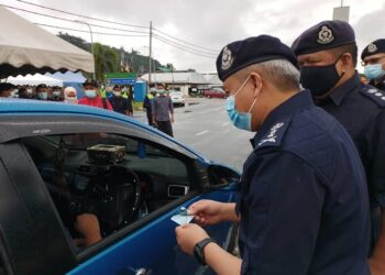 KASUAHDI Ali memeriksa kad pengenalan seorang pemandu pada Program Jeneral Turun Padang di Jalan Kuala Kangsar, Ipoh.