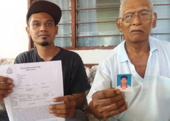 MA'AYOB (kanan) dan Jalaludin menunjukkan laporan polis serta gambar Muhammad Syukur yang hilang di Kampung Tambak Jawa, Jeram, Kuala Selangor, Selangor. UTUSAN/ISKANDAR SHAH MOHAMED