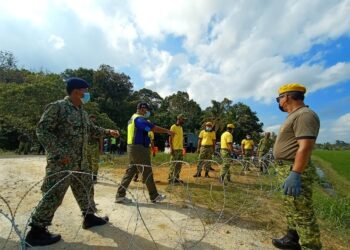 ABDUL Rozak Muhammad (dua kiri) meninjau kerja-kerja pemasangan kawat duri di Kampung Padang Baloh di Besut hari ini susulan Perintah Kawalan Pergerakan Diperketatkan (PKPD) di mukim Pasir Akar.