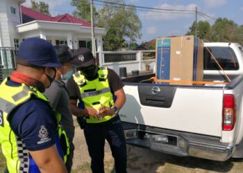 SEORANG lelaki (tengah) yang baharu lima hari bekerja sambilan sebagai penghantar barangan kurier ditahan polis kerana memiliki dadah dalam sekatan jalan raya di Ibu Pejabat Polis Daerah (IPD) Kemaman di Jalan Kerteh-Kampung Chabang di sini semalam. -UTUSAN/ NIK NUR IZZATUL HAZWANI NIK ADNAN