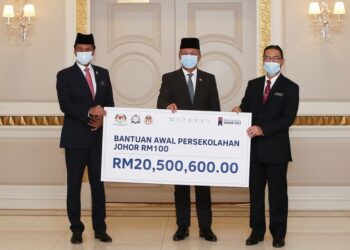 HASNI Mohammad (tengah) menyerahkan replika cek Bantuan Awal Persekolahan Johor RM100 sebanyak RM20,500,600 kepada Shaharuddin Saari (kanan) di Pejabat Menteri Besar di Kota Iskandar, Johor.