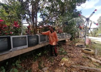 ABDUL Manat Ibrahim menunjukkan sebahagian koleksi televisyen rosak yang dikumpul bersama barangan terbuang lain di hadapan rumahnya di Kampung Paloh Nyiur, Hulu Terengganu. - UTUSAN/NOOR HAYATI MAMAT