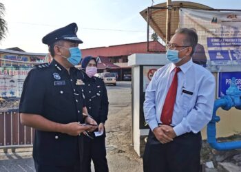 AFZANIZAR (kiri) bersama Pengetua SMK Munshi Abdullah, Batu Berendam, Melaka, Mohd. Yusri Seman selepas selesai memantau pematuhan SOP oleh calon-calon SPM. - UTUSAN/DIYANATUL ATIQAH ZAKARYA