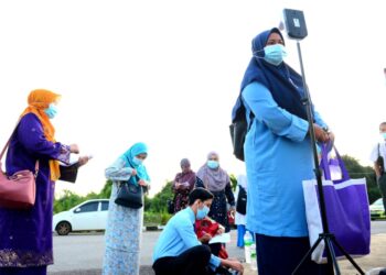 SEORANG pelajar SPM mengukur suhu sebelum masuk ke perkarangan sekolah untuk menduduki peperiksaan itu di SMK Seri Damai, Kuantan, Pahang. 
UTUSAN/SHAIKH AHMAD RAZIF