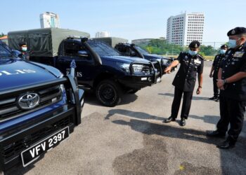 AYOB Khan Mydin Pithcay (kiri) bersama Khaw Kok Chin melihat kenderaan Toyota Hilux GS-Cargo Single Cab 2.4 sempena majlis penyerahan kenderaan itu untuk Kontinjen Johor di IPK Johor. -UTUSAN/RAJA JAAFAR ALI