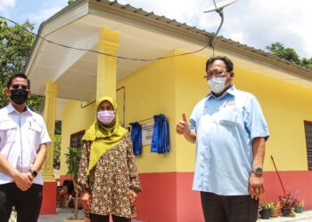 EDDIN Syazlee Shith (kanan) bersama Mahamad Farizan bergambar di hadapan rumah Zulzilah (tengah) selepas merasmikan Rumah Baitijannati, Tenaga Nasional Berhad (TNB) di Kampung Ghalib, Sungai Jelutong, Batu Kikir, Kuala Pilah hari ini.-UTUSAN/MUHAMMAD IZZAT TERMIZIE.