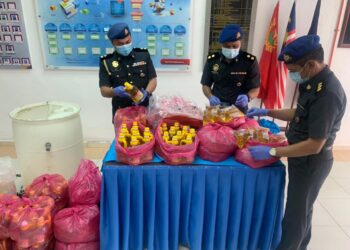 PEGAWAI  Penguat Kuasa  KPDNHEP Kulim memeriksa sebahagian minyak masak sabsidi yang di botol semula menjadi minyak sembahyang yang dirampas dalam serbuan di Taman Emas, Kulim semalam.