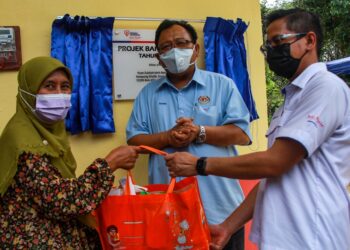 MAHAMAD Farizan Mahamad (kanan) menyampaikan cenderahati kepada Zulzilah sambil diperhatikan Eddin Syazlee selepas perasmian Rumah Baitijannati, Tenaga Nasional Berhad (TNB) milik Zulzilah di Kampung Ghalib, Sungai Jelutong, Batu Kikir, Kuala Pilah hari ini.-UTUSAN/MUHAMMAD IZZAT TERMIZIE.