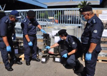 PEGAWAI JKDM menunjukkan peralatan memproses minuman keras yang ditemukan dalam serbuan kedua di kawasan perindustrian di Rawang, Selangor baru-baru ini.