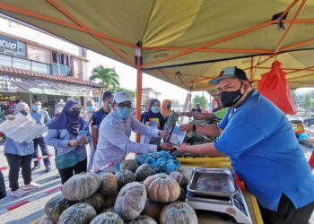 SHAHNON Mohamad (tengah) menyampaikan risalah kepada peniaga sempena program  'Info On Wheel' dan diperhatikan Asmizal (dua dari kanan) di Pasar Tani Taman Kemuning, Senawang, Seremban hari ini.-UTUSAN/AFIFI HAFIZ MOHD NOR