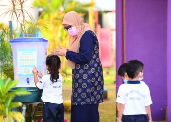 GURU SK Kampung Belukar, Shuhadah Mohd. Nasir mengajar murid pra sekolah mencuci tangan pada sesi persekolahan yang bermula hari ini. -  
UTUSAN/SHAIKH AHMAD RAZIF