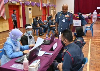 ABU OBAIDAT Mohamad (berdiri) meninjau proses vaksinasi anggotanya di Ibu Pejabat Bomba Negeri Melaka, Bukit Katil, Melaka. - UTUSAN/DIYANATUL ATIQAH ZAKARYA