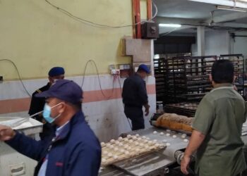 ANGGOTA penguat kuasa KPDNHEP negeri Perak kilang memproses roti dan biskut yang menggunakan logo halal  tanpa kebenaran di sebuah kawasan perindustrian di Ipoh semalam. - UTUSAN/GAMBAR IHSAN KPDNHEP PERAK