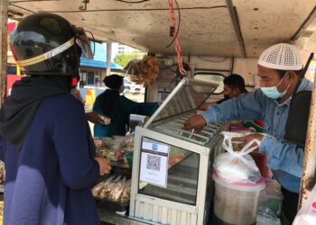 MANSYUR Hamad menjual colek buah di hadapan bangunan Wisma Persekutuan Jalan Bayam, Kota Bharu.-UTUSAN/ROSLIZA MOHAMED