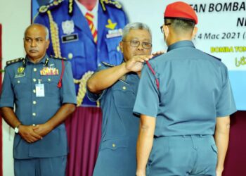 SOIMAN Jahid (tengah) memakaikan tanda pangkat KB22 kepada penerima pada majlis lawatan kerja rasmi  ke JBPM Melaka di BBP Bukit Katil, Melaka. - UTUSAN/RASUL AZLI SAMAD