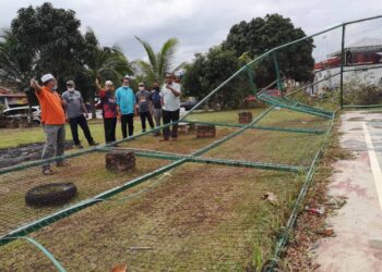 MOHAMAD Zain (kanan sekali) melihat keadaan pagar futsal yang terjejas selepas dilanda ribut dan hujan di Taman Seroja, Sepang, hari ini. UTUSAN/NUR SHARIEZA ISMAIL