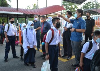 MOHD. Radzi Jidin (kanan) meninjau proses kemasukan murid ke sekolah yang memulakan sesi persekolahan hari ini  di SK King George V, Seremban hari ini.-UTUSAN/ZAKKINA WATI AHMAD TARMIZI.