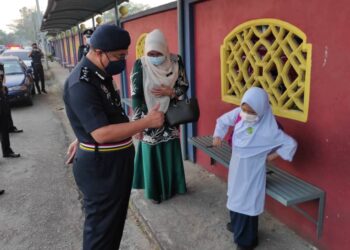 SHAFIEN Mamat berkata sesuatu kepada salah seorang murid di Sekolah Kebangsaan Mulong 2, Kota Bharu. - UTUSAN/ROHANA MOHD. NAWI