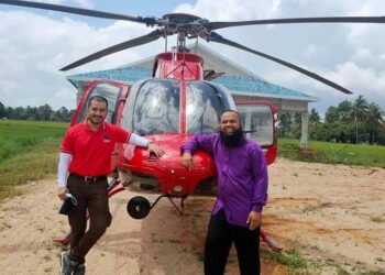 MOHAMAD Azlan Abdullah @ Ali (kanan) bergambar di depan helikopter di Kampung Tok Raja, Besut, Terengganu, ketika pulang bercuti pada minggu lalu.