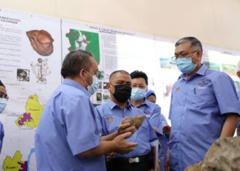 SAARANI Mohamad (tengah) dan Shamsul Anuar Nasarah (kanan) diberikan penerangan mengenai bahan yang dipamerkan di Galeri Lenggong Geopark di Lenggong.