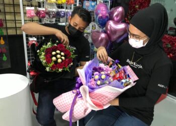 PASANGAN suami isteri, Mohd Zaki dan Siti Sarah mencari rezeki dengan menghasilkan dekorasi berasaskan belon dan bunga di Kota Bharu.-UTUSAN/ ROSLIZA MOHAMED