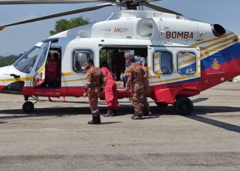 ANGGOTA Unit Udara JBPM membawa lelaki yang mengalami serangan jantung keluar dari kawasan hutan di Sungai Singgor, Kampung Tekam ke lapangan terbang Gerik hari ini. - UTUSAN/GAMBAR IHSAN JBPM