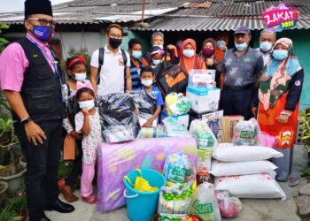 NASIR Ishak (kiri) ketika menyampaikan sumbangan daripada MAINJ kepada keluarga Ronimah Haron (tengah) ketika mengadakan kunjungan bersempena program Jejak Asnaf MAINJ di Johor Bahru, Johor.