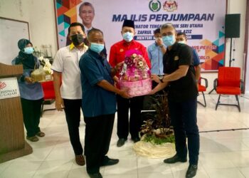 TENGKU Zafrul (kanan) menerima cenderahati daripada Nurulhisham pada majlis pertemuan dengan pengusaha harumanis Perlis di Pusat Khidmat Kubang Gajah, Arau, Perlis hari ini.- UTUSAN/MOHD. HAFIZ ABD. MUTALIB