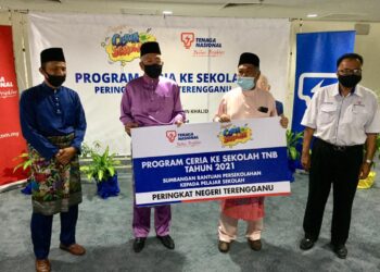 MAHDZIR Khalid (dua, kiri) menyampaikan replika sumbangan bantuan persekolahan pelajar Terengganu kepada Ahmad Said (dua, kanan) pada Program Ceria Ke Sekolah Tenaga Nasional Berhad (TNB) 2021 di Kuala Nerus hari ini. -UTUSAN/TENGKU DANISH BAHRI TENGKU YUSOFF