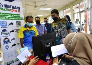 ZAHIDI (kanan) beramah mesra dengan penduduk yang mendaftar pengambilan vaksin semasa Program Jelajah Malaysia Prihatin di Dewan Kemas Alor Tampang, Beseri, Perlis hari ini.- UTUSAN/NAZLINA NADZARI