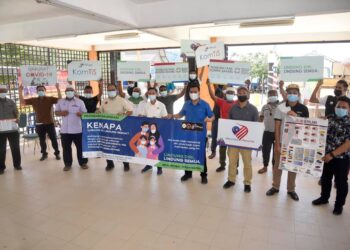 AHMAD Ammar Othman (empat dari kanan) bersama penduduk Pulau Perhentian menunjukkan plakad dan risalah kempen pembudayaan norma baharu di Pulau Perhentian di Besut, semalam.