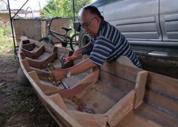 ARIFFIN Tumpang sedang menyiapkan perahu golek di rumahnya di Felda Jengka 11 di Maran, Pahang.