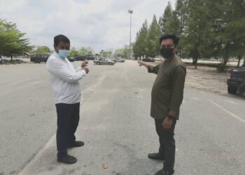 RASYDAN Zahir (kanan) dan Setiausaha Japerun Klebang, Kamaruddin Hussin menunjukkan tapak jualan but kereta yang akan dijadikan tapak Bazar Ramadan Mega Pantai Klebang, Melaka. - UTUSAN/AMRAN MULUP