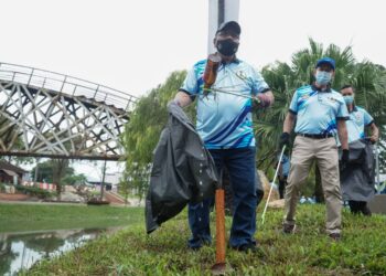 MOHD. Zolkafly Harun (depan) membersihkan sampah di tebing Sungai Kinta pada program gotong royong Denai Sungai Kebangsaan Sempena Hari Air Sedunia Tahun 2021 di Dataran Sungai Kinta, Ipoh hari ini. - UTUSAN/ZULFACHRI ZULKIFLI